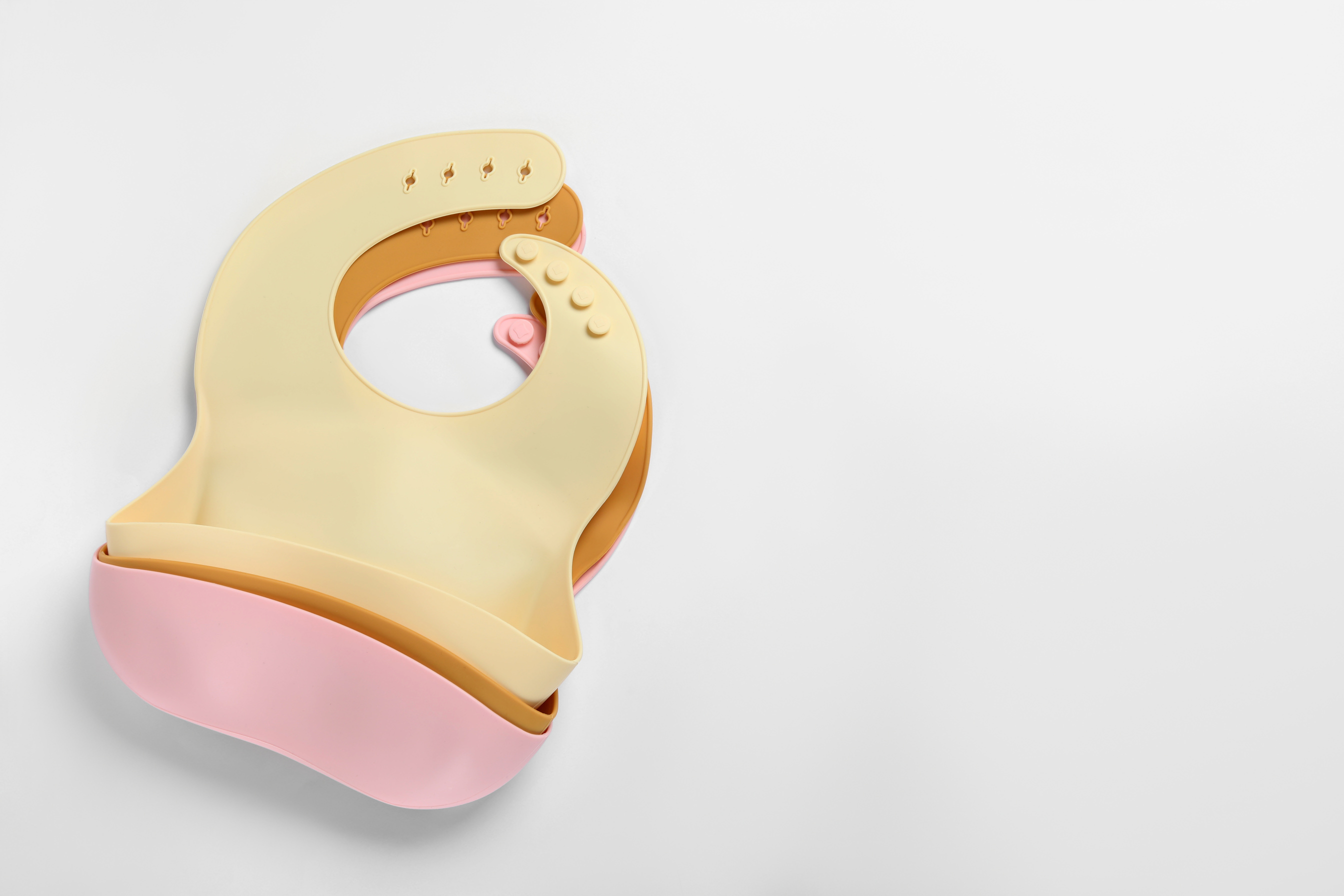 Color Silicone Baby Bibs on White Background, Top View
